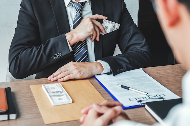 Businessman giving dollar bills corruption bribery to business manager 