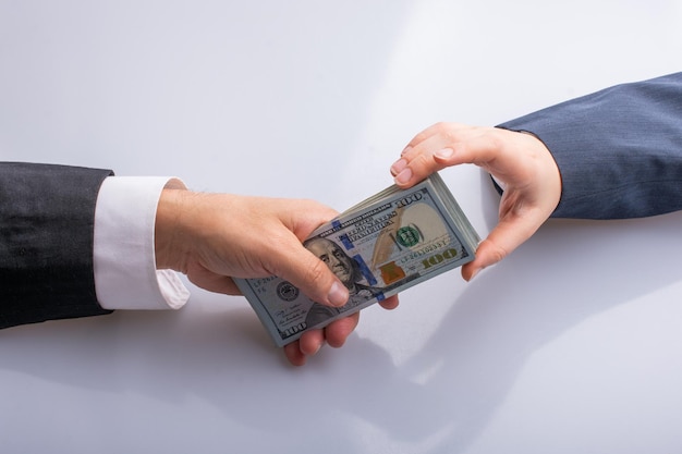 Businessman giving and receiving dollar banknote money