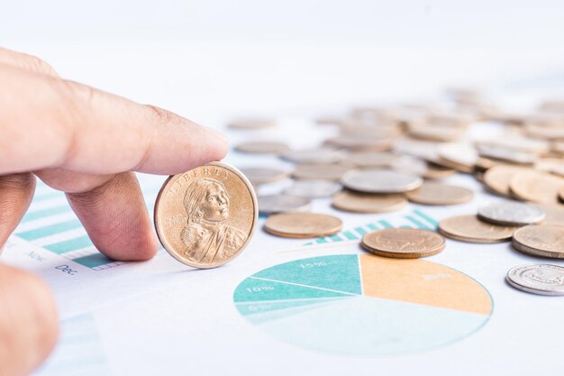 Businessman hand and coins on paper graph chart.For business and financial concept ideas.