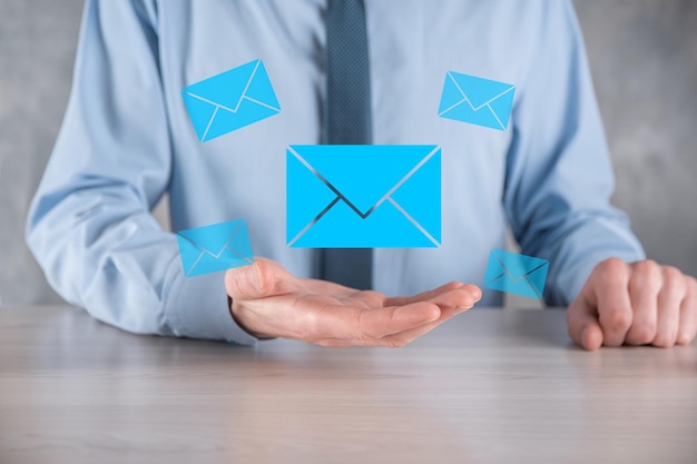 Businessman hand holding email icon Contact us by newsletter email and protect your personal information from spam mail Customer service call center contact us concept