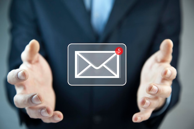 Businessman hand holding email icon Contact us by newsletter email