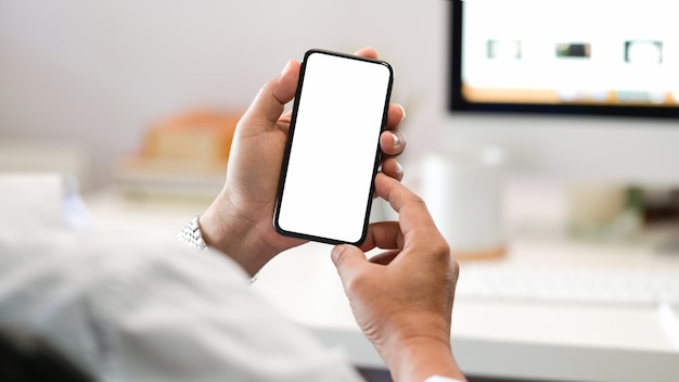 Businessman hand holding mobile smartphone in office