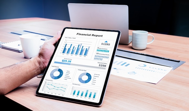 Businessman hand holding tablet with mock up financial report slide show presentation on display