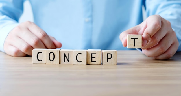 Businessman hand holding wooden cubes with concept word business concept