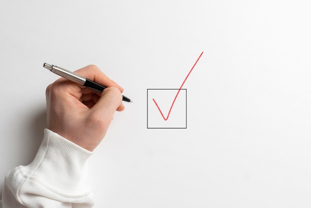 A businessman hand sign check mark box with a pen view from above