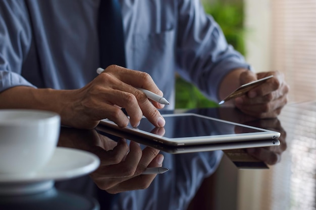 Businessman hand using digitized pen and work on digital tablet at workplace