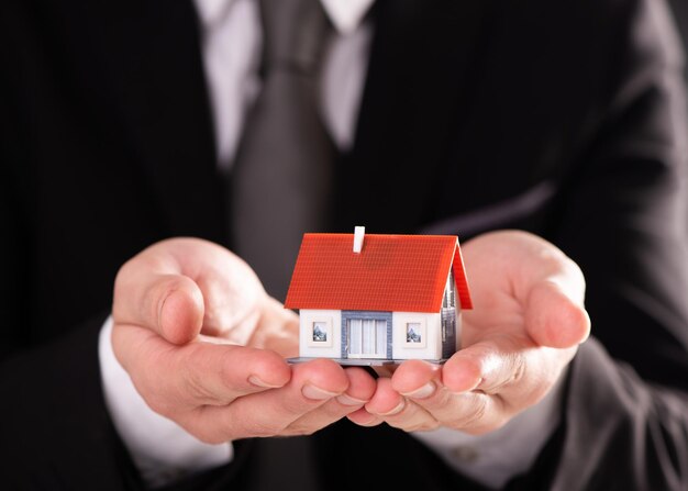 A Businessman hand with model house home concept