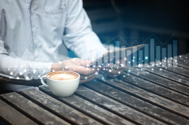 Businessman hand working on laptop computer with graph chart of stock market investment trading