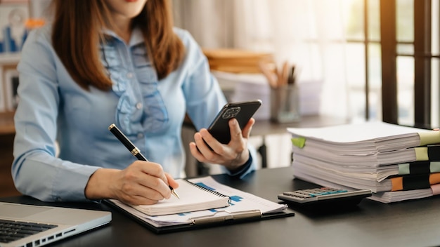 Businessman hand working with new modern computer and writing on the notepad strategy diagram as concept