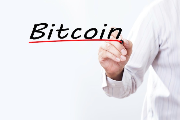 Businessman hand writing Bitcoin with red marker on transparent wipe board business concept