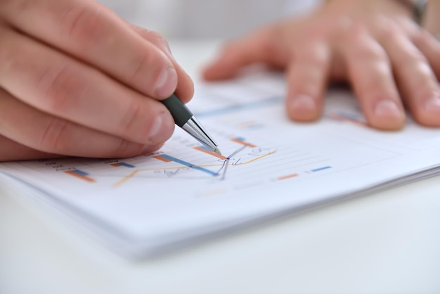 Businessman hands analyzing financial report and statistics