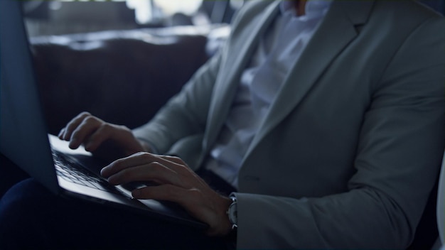 Businessman hands working computer dark interior close up Boss writing email