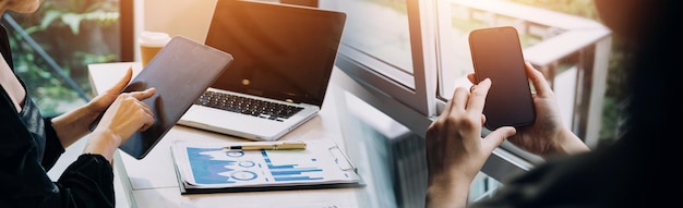 Businessman hands working with finances about cost and calculator and laptop with tablet smartphone at office in morning light