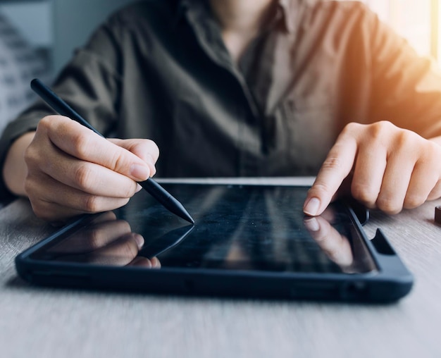 Businessman hands working with finances about cost and calculator and laptop with tablet smartphone at office in morning light