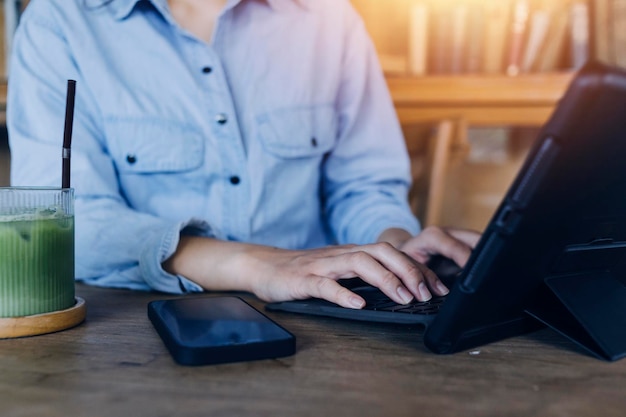 Businessman hands working with finances about cost and calculator and laptop with tablet smartphone at office in morning light