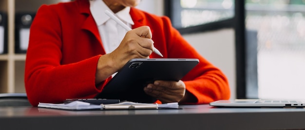 Businessman hands working with finances about cost and calculator and laptop with tablet smartphone at office in morning light