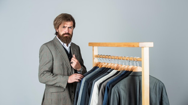 Businessman handsome guy in clothes shop choosing garments menswear concept