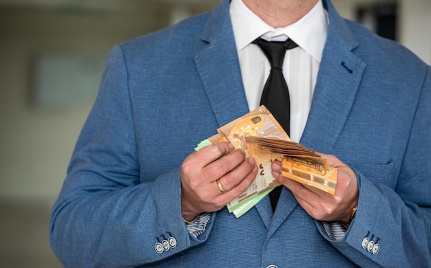 Businessman hiding euro bills in a suit pocket