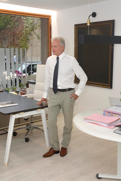 A businessman in his office standing and looking a way