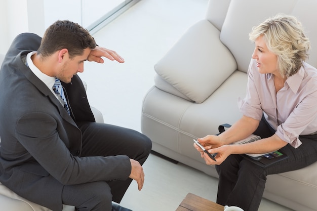 Businessman and his secretary  sitting on sofa at home