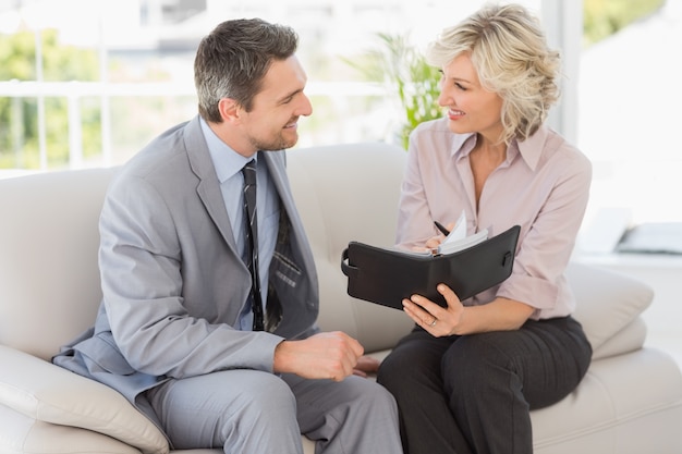 Businessman and his secretary  with diary at home