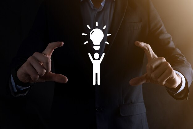 Businessman hold man icon with light bulbs, ideas of new ideas with innovative technology and creativity. concept creativity with bulbs that shine glitter.