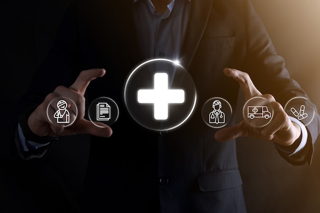 Businessman hold virtual plus medical network connection icons. Covid-19 pandemic develop people awareness and spread attention on their healthcare.Doctor,document,medicine,ambulance,patient icon.