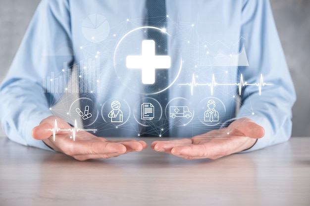 Businessman hold virtual plus medical network connection icons. Covid-19 pandemic develop people awareness and spread attention on their healthcare.Doctor,document,medicine,ambulance,patient icon.