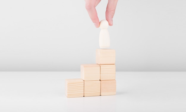 Businessman hold wooden man representing leader steps up success with standing on top of staircase