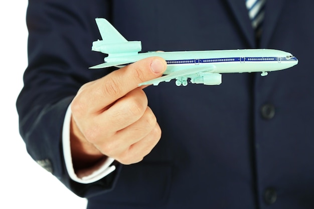 Photo businessman holding airplane model in hand closeup