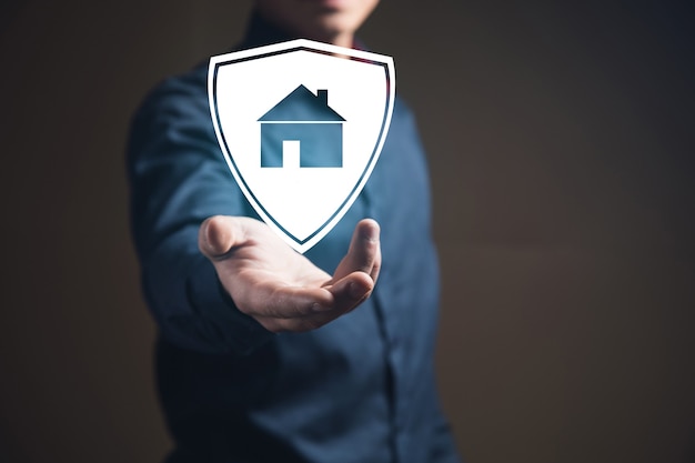 Businessman holding a billboard with a house. Home safety