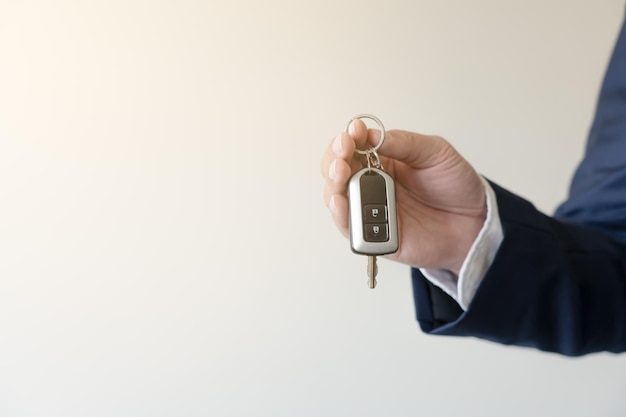 Businessman holding car key concept of buy new vehicle car