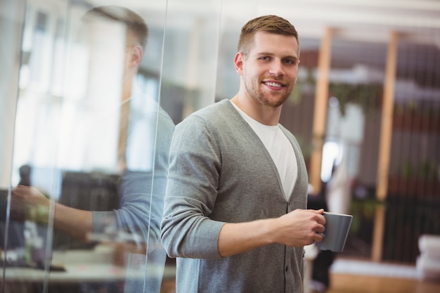 Businessman holding coffee cup in office