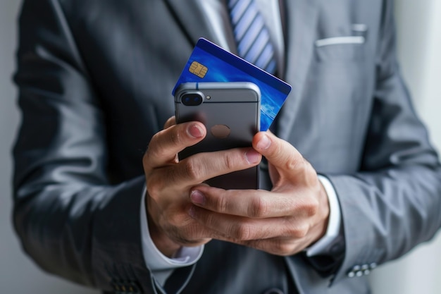 Photo businessman holding a credit card and smartphone isolated on a white background with copy space