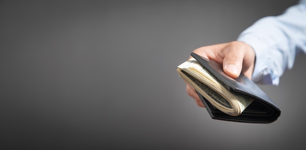 Businessman holding dollars with wallet