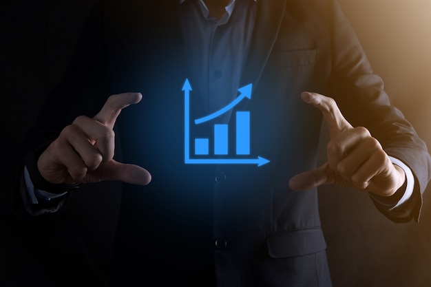 Businessman holding a graph with positive profits growth