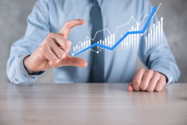 Businessman holding a graph with positive profits growth.