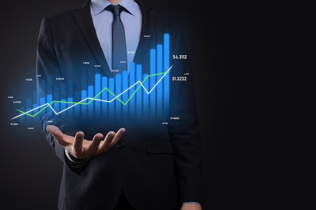 Businessman holding holographic graphs and stock market statistics gain profits