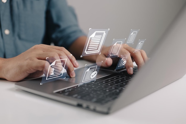 Businessman holding a laptop with a document management icon in it while utilizing the data system for business on the internet