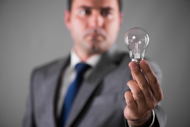 Businessman holding light bulb in creativity concept