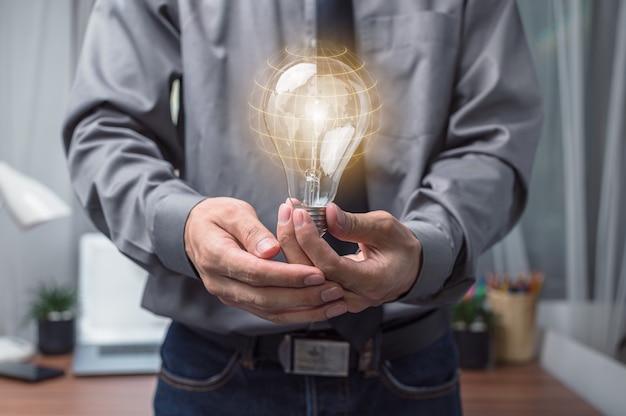 Businessman holding a light bulb and thinking of new ideas