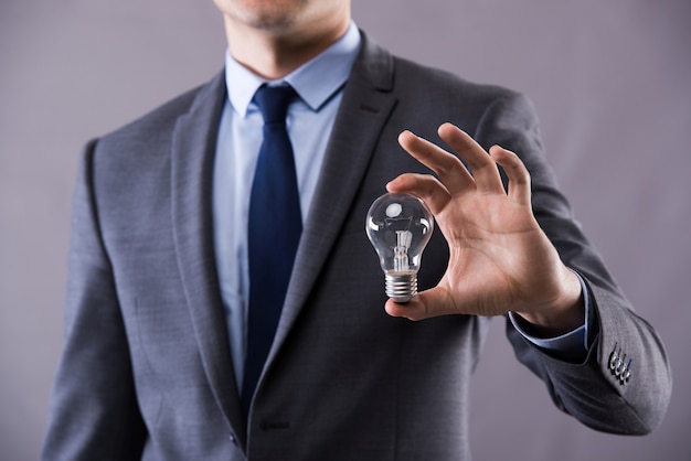 Businessman holding light bulb 