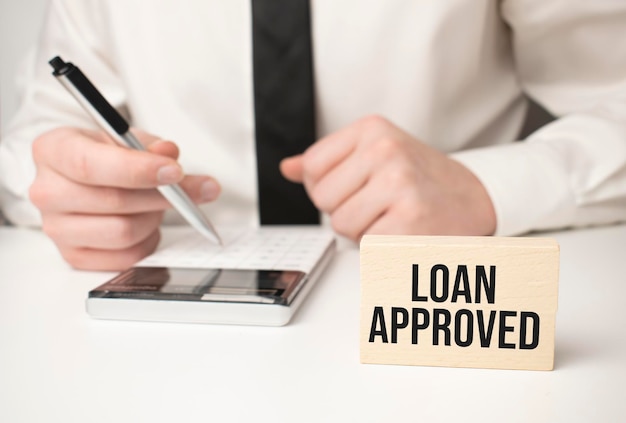 Businessman holding sheet of paper with a message Loan approved