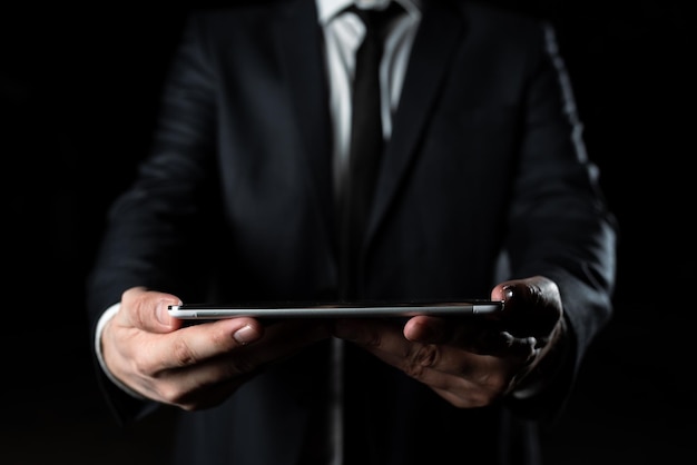 Businessman holding tablet with both hands and presenting important data man in suit showing