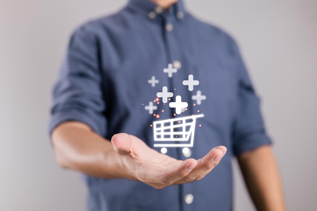 Businessman holding virtual shopping cart symbols with a plus sign to add or receive an order