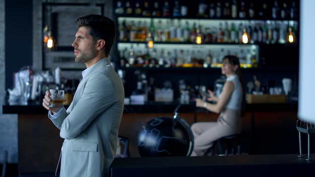 Businessman holding whiskey glass at cafe Elegant people resting concept