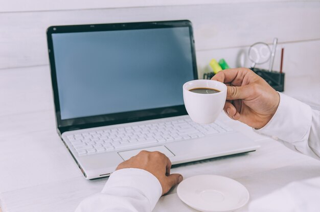 Businessman holds a cup of coffee in his hands