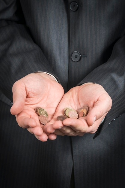 businessman holds in his hands a few euro coins, close-up