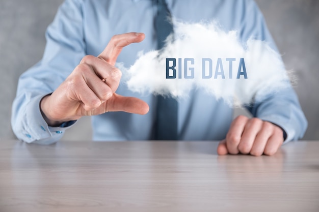 Businessman holds the inscription BIG DATA. Padlock , brain ,man, planet,graph, magnifier, gears, cloud, grid, document, letter, phone icon.