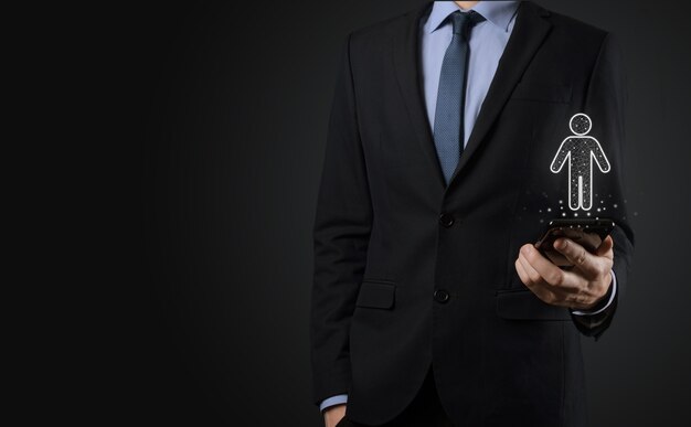 Businessman holds man person icon on dark tone background.HR Human ,people iconTechnology Process